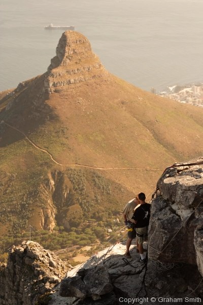 Abseiling off Table Mountain with Lion's Head in the distance